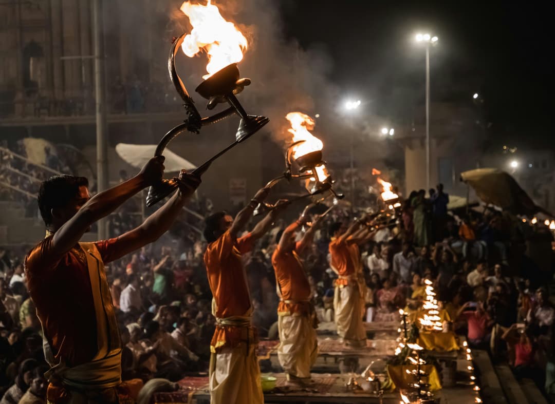 Evening Ganga Aarti ceremony at Dashashwamedh Ghat Varanasi with priests performing rituals by the river.