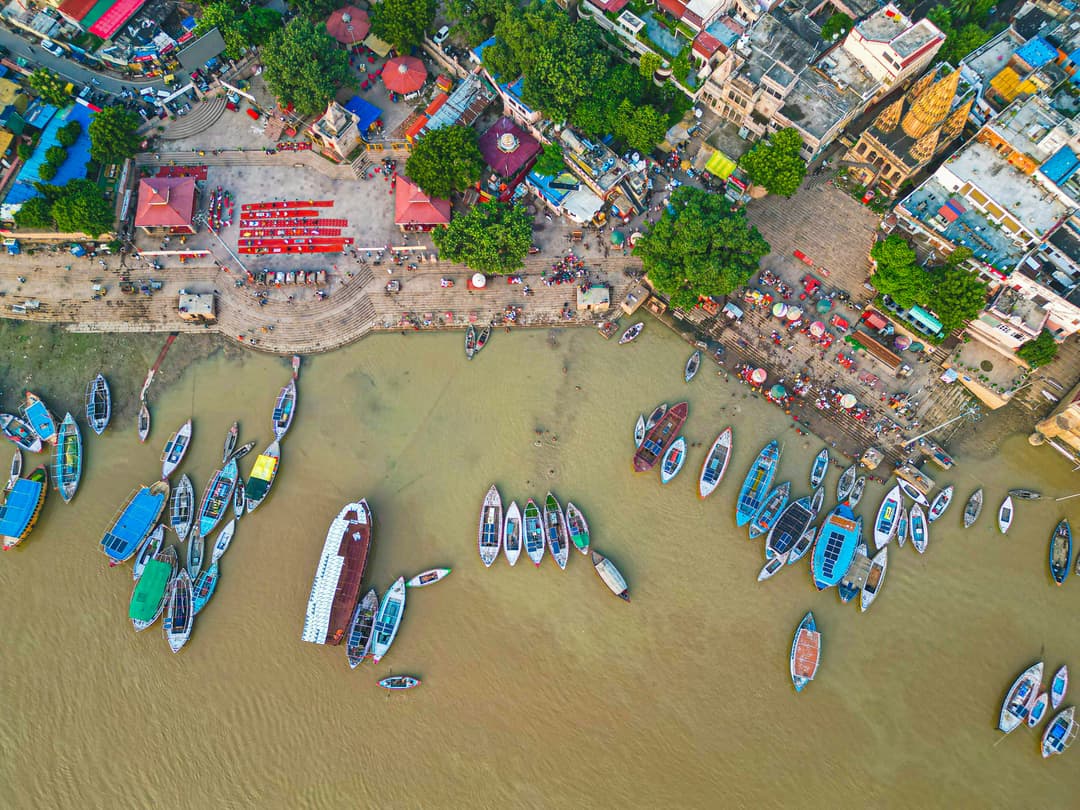 Beautiful top view of Assi Ghat with the Ganges River and boats along the shore in Varanasi.