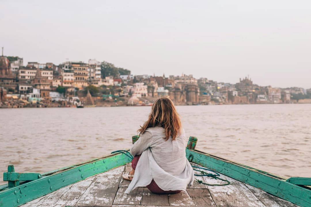 Boating along the ghats of Banaras with views of temples and historic structures by the Ganga River.