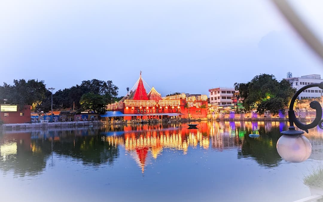 Vibrant Durga Mata Mandir at Durgakund with its striking red facade and serene temple pond in Varanasi.